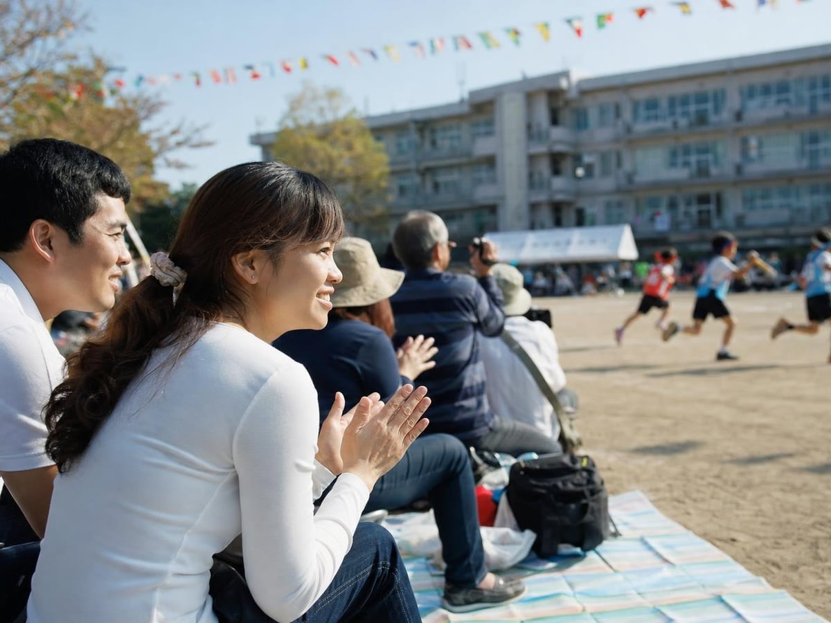 parents cheer from picnic mats at an elementary school sports day
